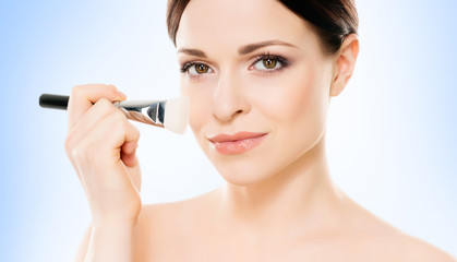 Portrait of young, beautiful and healthy woman: over blue background. Healthcare, spa, makeup and face lifting concept.