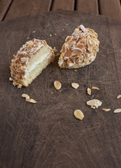 Sara cake (Sarah Bernhardt). Genoise Sponge cake with almonds on a wooden board.