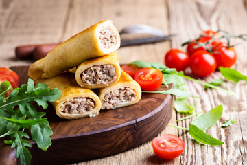 Minced beef stuffed crepes with arugula salad