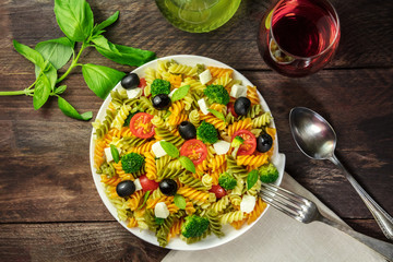 Pasta salad with basil and wine on rustic texture