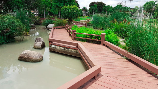 wooden walk way with landscape of garden and pond