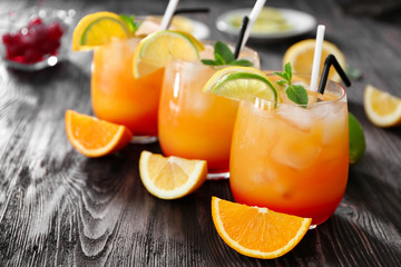 Glasses of Tequila Sunrise cocktail on wooden table