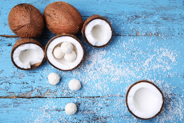 Coconuts with candies on blue wooden table