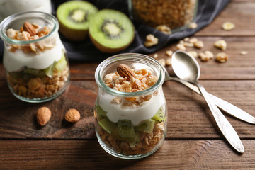 Delicious muesli with kiwi and yogurt on wooden table