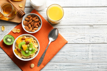 Corn flakes with fruits and almonds on table
