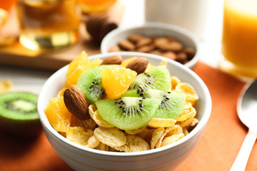 Corn flakes with fruits and almonds on table