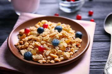 Delicious muesli with berries on wooden table