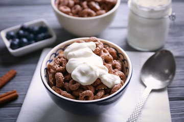 Chocolate corn rings with yogurt on wooden table