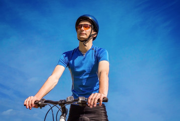 Fototapeta na wymiar Young bicyclist against the sky
