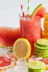frisch gepresster Saft im Glas mit geschnittenen Zitrusfrüchten und Eiswürfeln garniert