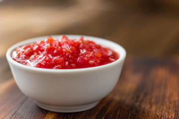 Indian chutney or mexican salsa in white ceramic bowl.