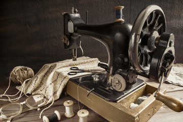 Old antique sewing machine, thread, glasses Concept of manual labor, hobbies and history