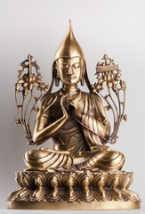Bodhisattva Avalokiteshvara - a figure from bronze sitting on a white background in a pose of a lotus, a hands in  Dkharmachakra-mudra.