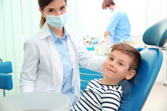 Cute little boy and dentist in clinic