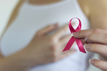 Woman hold pink ribbon for breast cancer awareness - obrazy, fototapety, plakaty