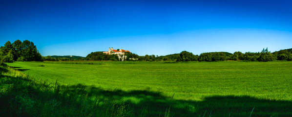 Panorama widoku na Opactwo Benedyktynów w Tyńcu, na pierwszym planie łąka.