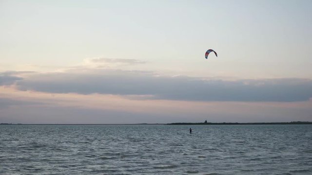 Kitesurfing at sunset at sea