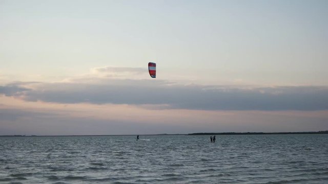 Kitesurfing on a sunset background at sea