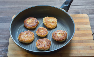 fried curd cottage cheese pancakes in frying pan, close up