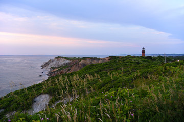 Fototapeta na wymiar Gay Head Lighthouse and Gay Head cliffs of clay at the westernmost point of Martha's Vineyard in Aquinnah, Massachusetts, USA. This historic lighthouse was built in 1856.
