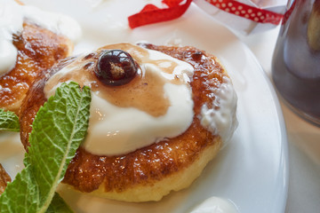 curd cottage cheese pancake on white plate with raisins, mint and currant berries. close up macro shot