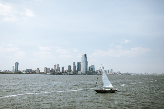 sailboat in front of manhatten skyline