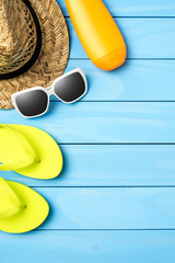 Beach or summer accessories on blue wooden background