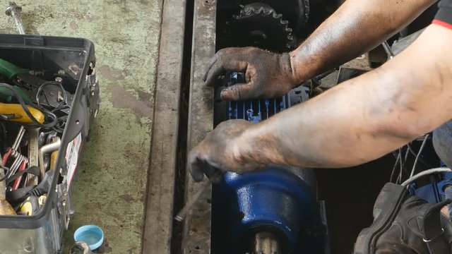 4k of Hand of repairman holding hexagonal wrench and during maintenance work of electric motor