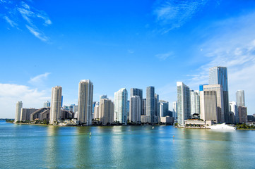 Fototapeta na wymiar Miami skyscrapers with blue cloudy sky, boat sail, Aerial view