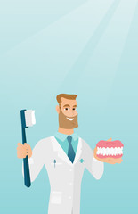 Dentist with a dental jaw model and a toothbrush.