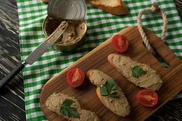 Liver pate on the bread on wooden tray.
