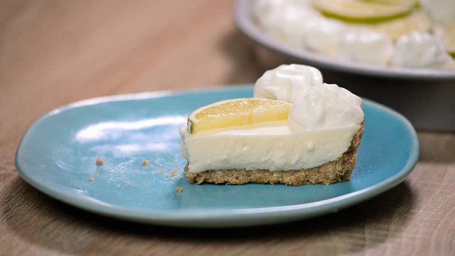 Slice of key lime pie with fresh limes and a garnish. Eat lime cake