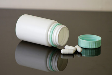 Frasco de remédios e alguns comprimidos