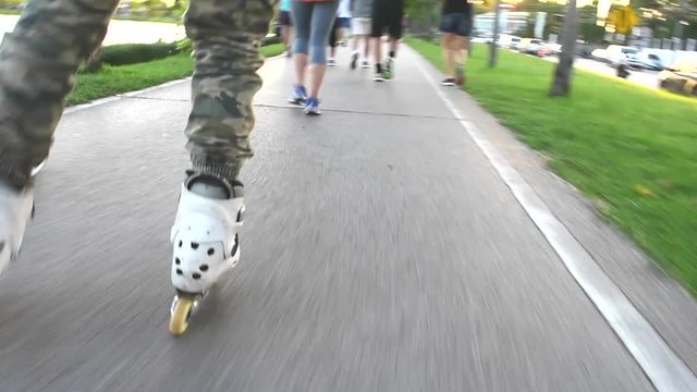  People on Roller Skates. Rollerblades Close Up. and people run in park