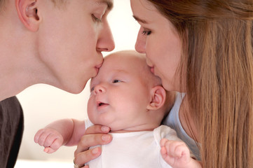 Closeup portrait of beautiful young family with newborn