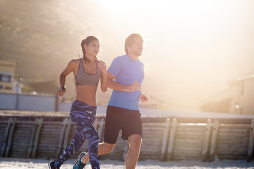 Healthy Couple Running together sun flare behind