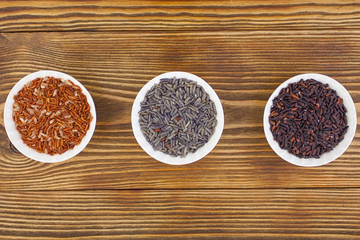 Raw blue rice in bowl on  wooden background