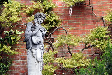 Statue of the Greek God Pan in a walled garden