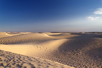 Fototapeta na wymiar Песчаные холмы на фоне синего неба