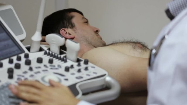 Close-up of medical ultrasound. Doctor scanning body of caucasian male patient.