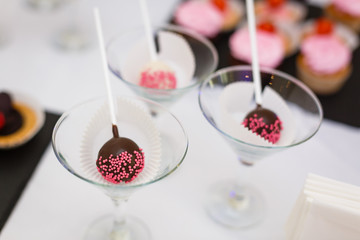 Home made chocolate cake pop decorated with pink and white sugar sprinkles.
