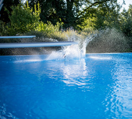 Water splash in swimming pool after jump in the water