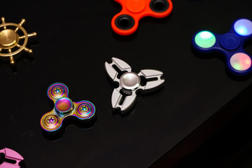 Hand spinners or fidgeting spinners. Many types and shapes of spinners put on the black background.