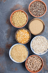 Different grains and cereal on the grey stone background, top view, selective focus