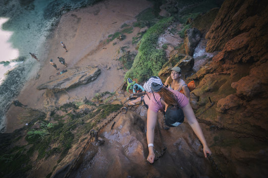 Backpackers descending down sketchy chains to view paradise at Mooney Falls