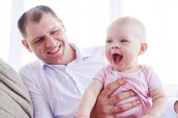 Smiling dad holding joyful little girl