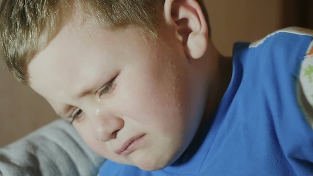 The boy wipes his tears. the baby cries. slow motion