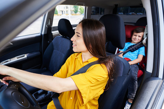 Nice Woman Driving Car With Son Sitting In Baby Seat