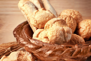Baked basket with fresh bread on wooden background
