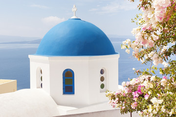 Fototapeta na wymiar Church with blue dome and purple flowers 